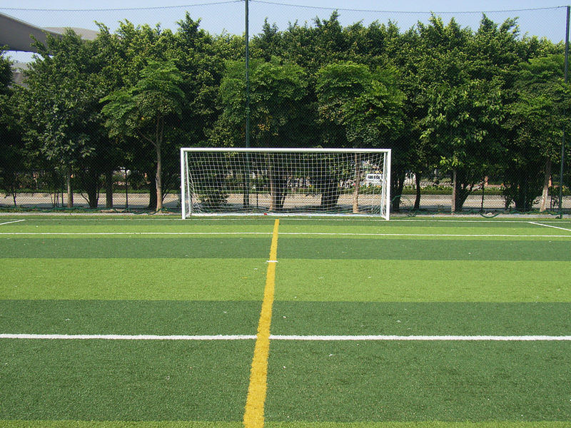 Jogador de futebol ou futebol na parede branca com grama